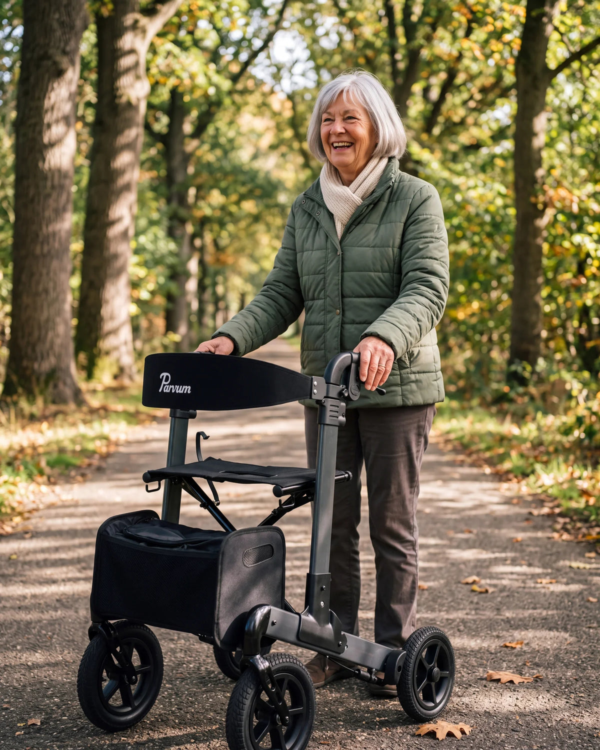 Parvum Luxo Air in anthracite under oak trees; a woman with gray hair laughs, her hands on the handles.