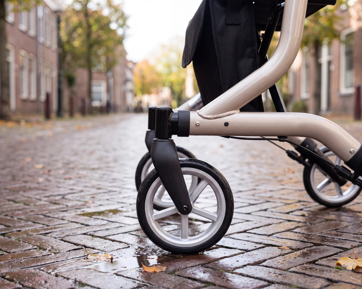 Close-up of the silver front wheel of the Parvum SuperLight in champagne on wet cobbles.