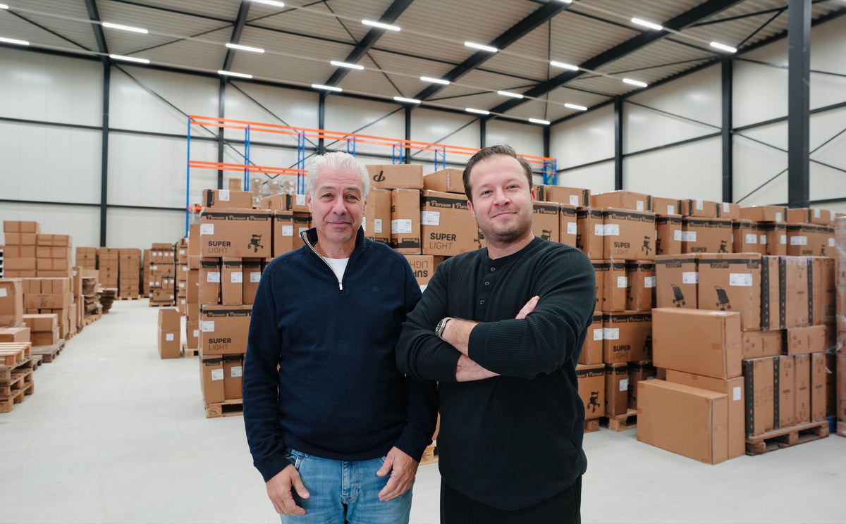 Founders of Parvum standing in the warehouse among boxes of rollators